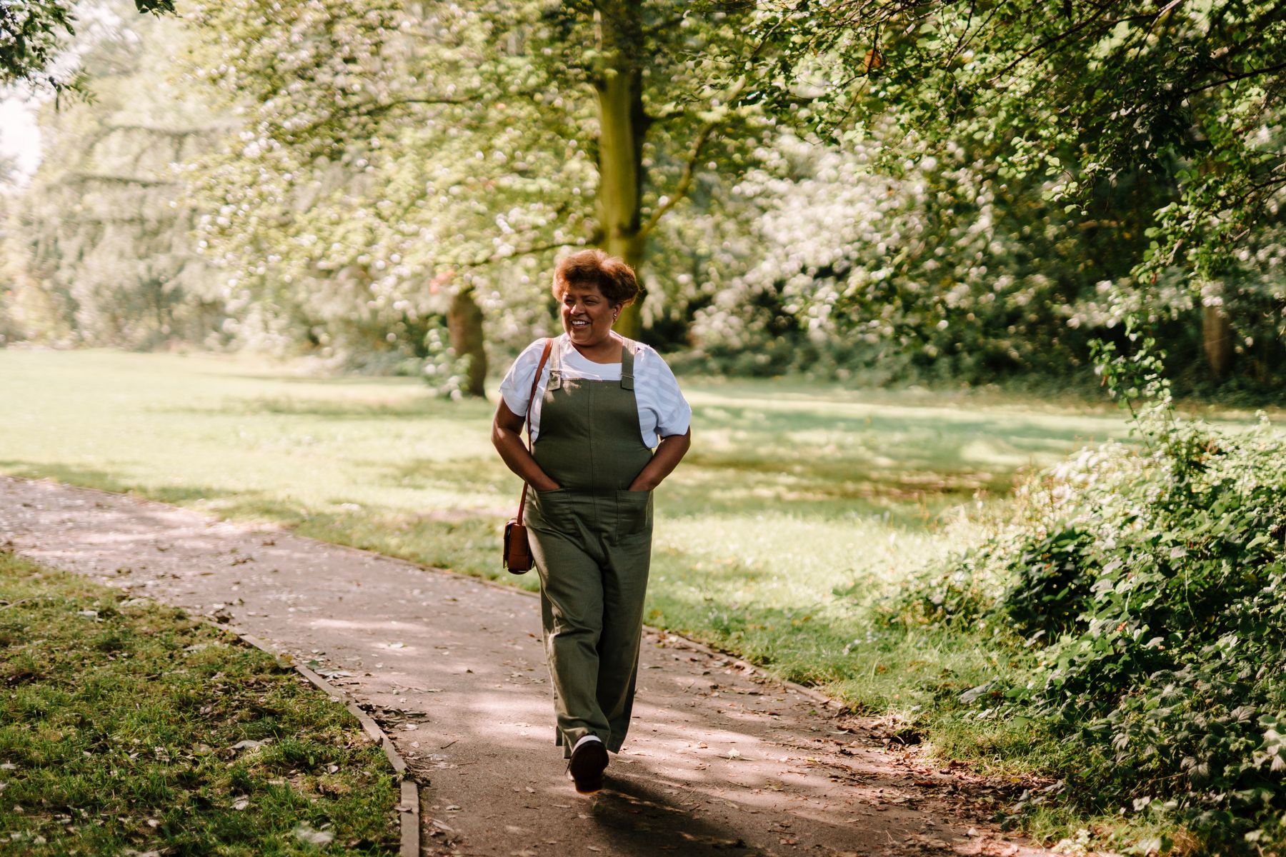 Woman enjoying a relaxed walk through a sunlit park